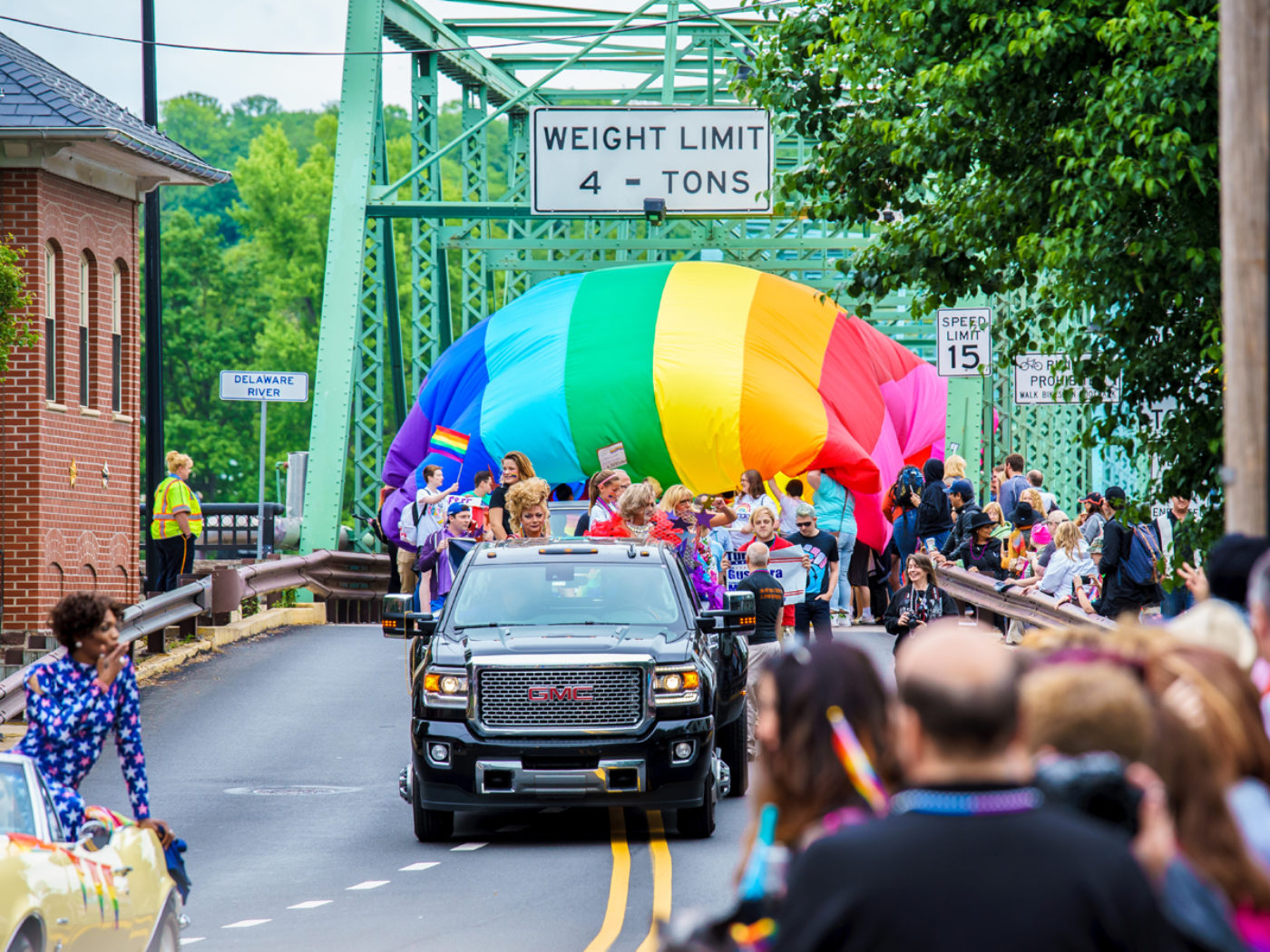 The Pride Parade with the giant rainbow flag crossing the bridge into New Hope during New Hope Celebrates Pride Week