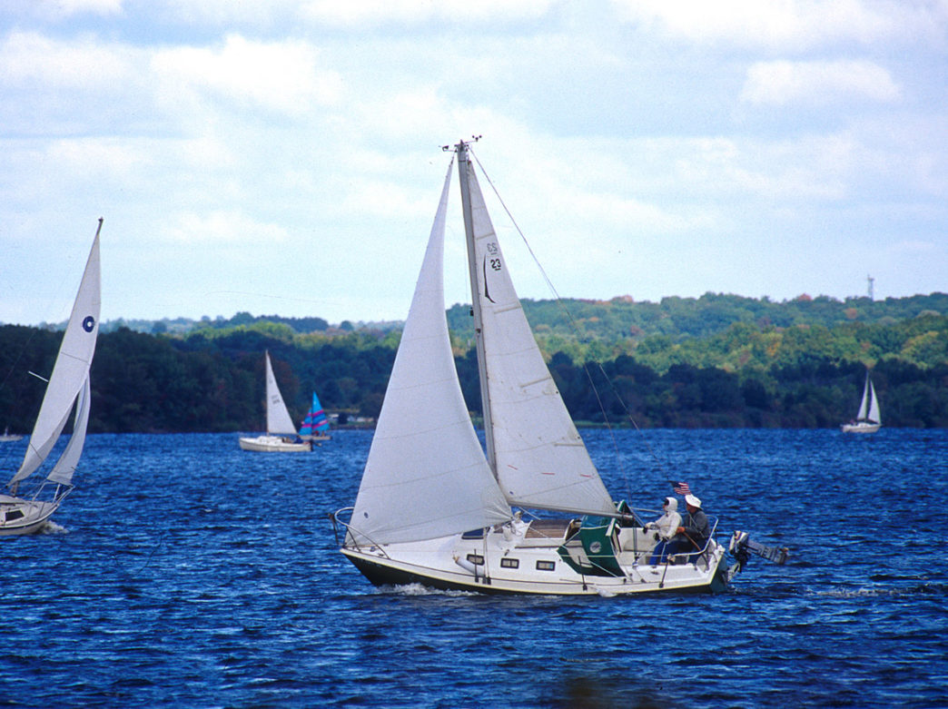 Sailboats cruise around Lake Nockamixon on sparkling blue waters