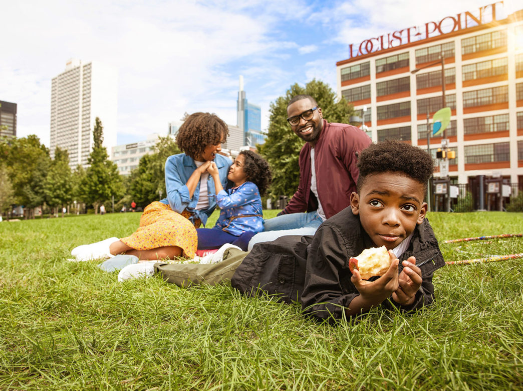 A family lounging in the grass by the Schuylkill Banks in Philadelphia