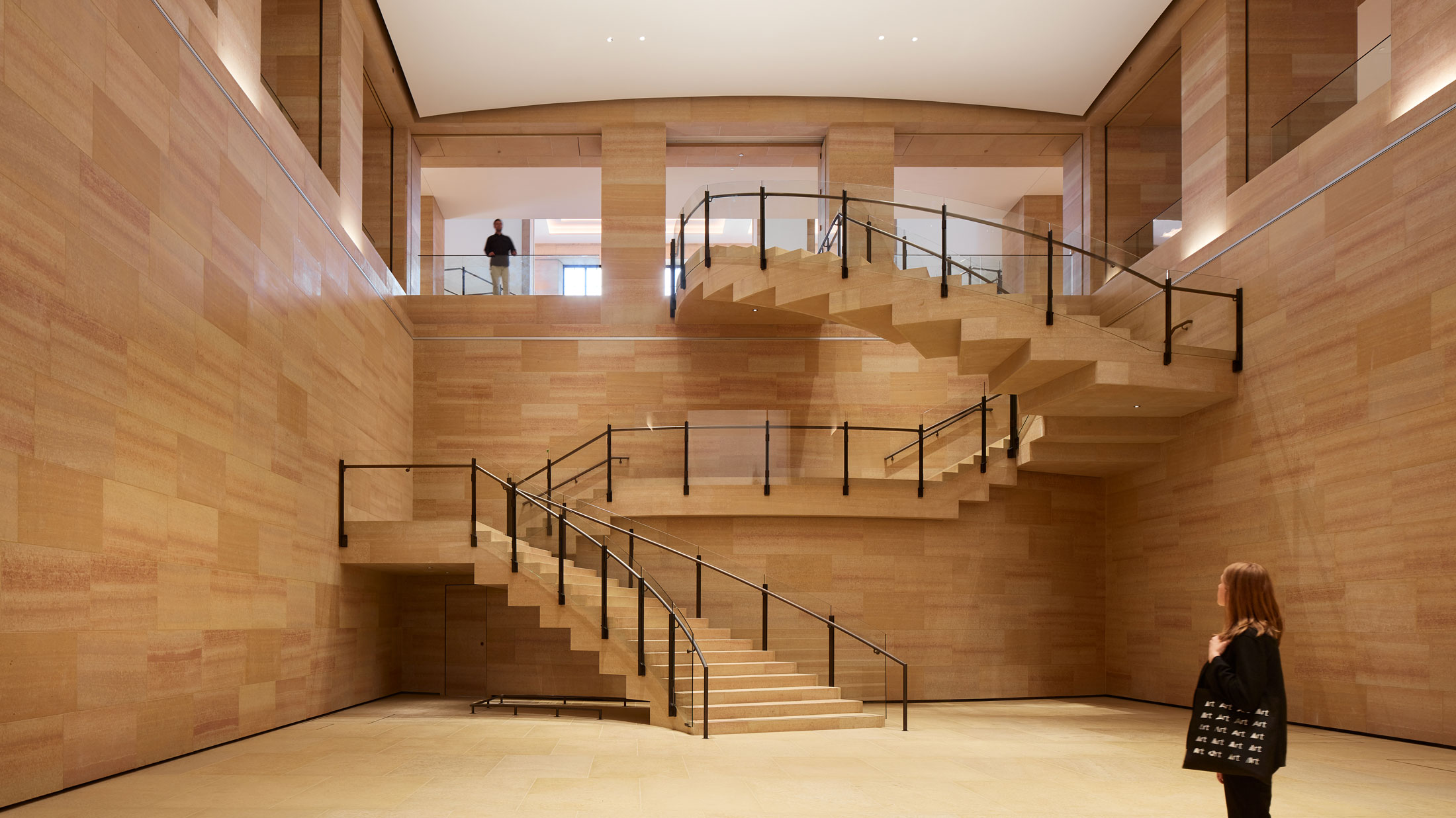 A woman stands at the base of the new Frank Gehry-designed stairs inside the Philadelphia Museum of Art
