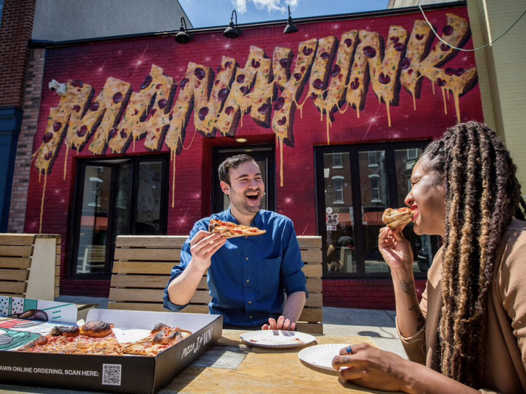 People eating outside of Pizza Jawn