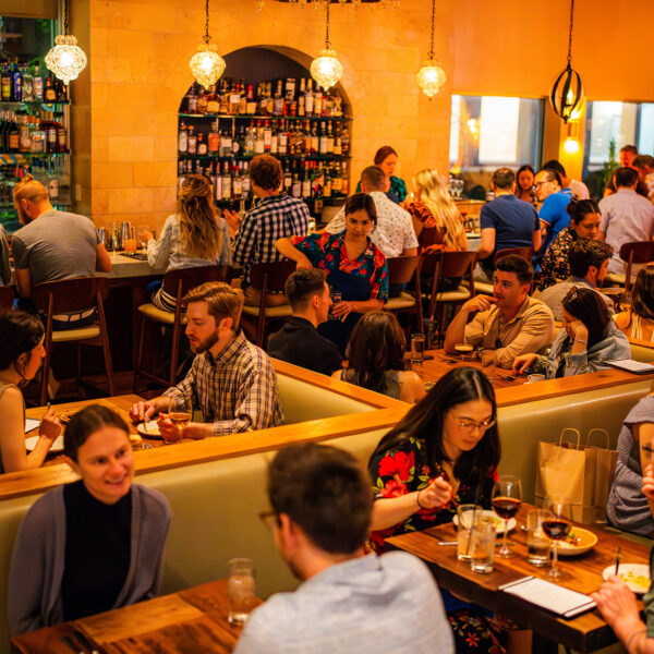 A full dining room of people eating in a busy restaurant.