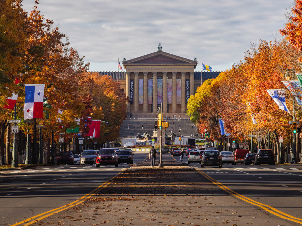 The exterior of the Philadelphia Museum of Art surrounded by foliage on an autumn day.