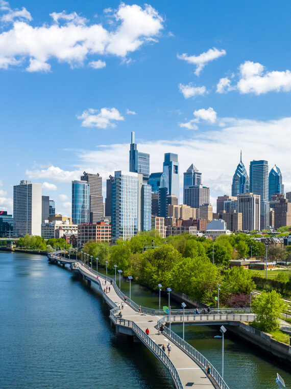 The Philadelphia skyline on a sunny day with the Schuylkill River and Schuylkill Banks Boardwalk in the foreground