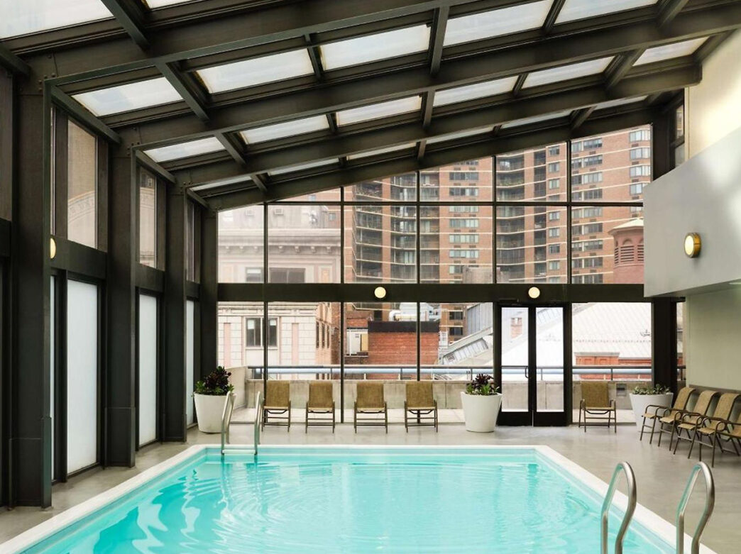 Indoor pool at the DoubleTree by Hilton Hotel Center City. The pool is surrounded by floor to ceiling windows and a glass roof.