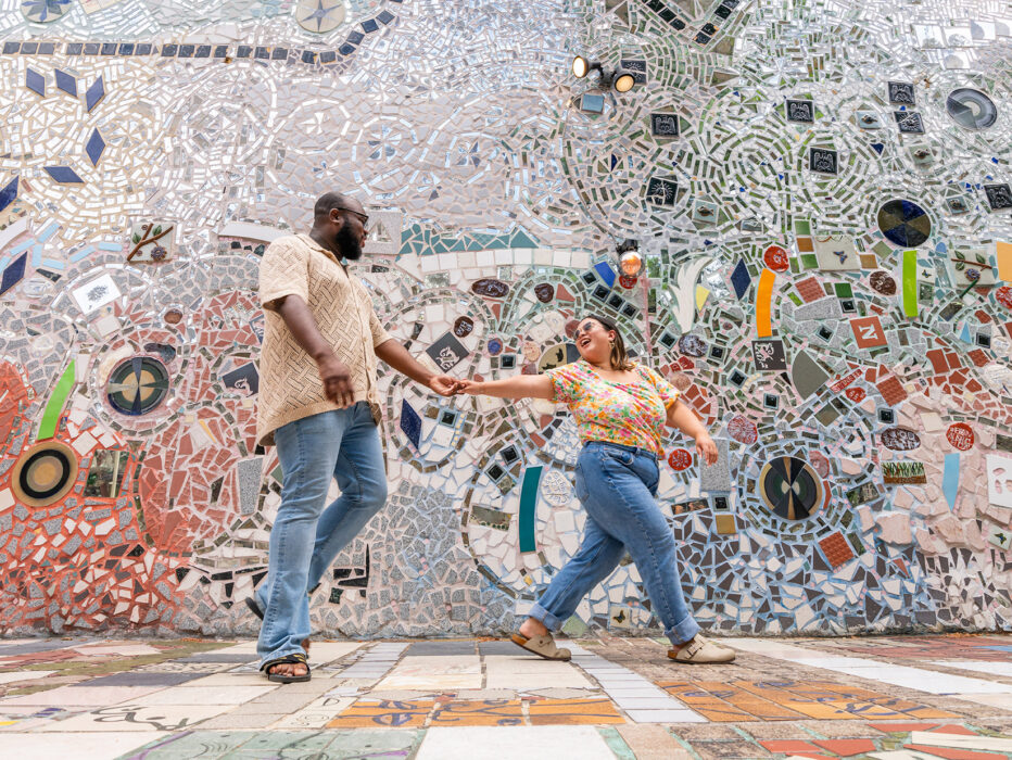 One person leads another through the mosaics at Philadelphia's Magic Gardens.