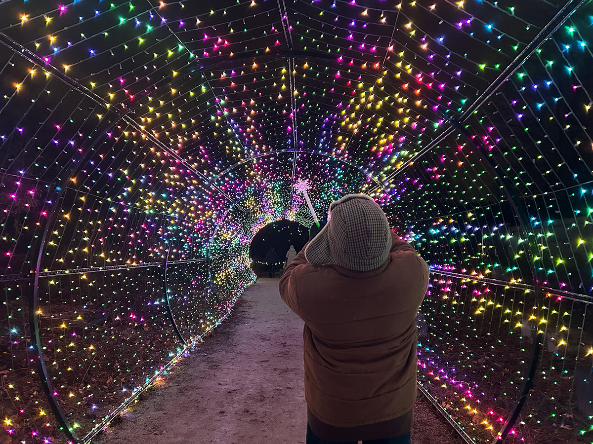 Sabrina's father takes a photo of the vibrant tunnel of colorful lights.
