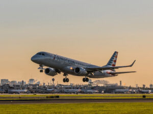 A white American Airlines plane takes from the tarmac at Philadelphia International Airport at sunset.