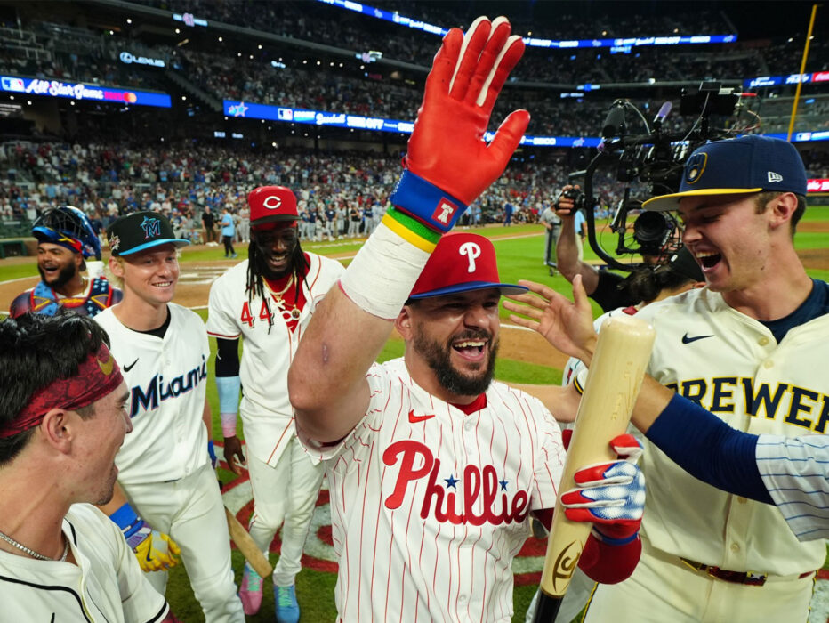 Kyle Schwarber reaches for a high five from his teammates on the field during the MLB All-Star Game.
